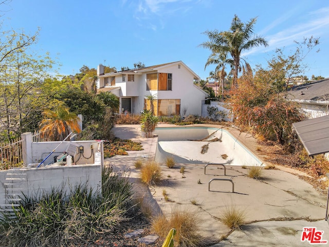 view of front of property with an empty pool