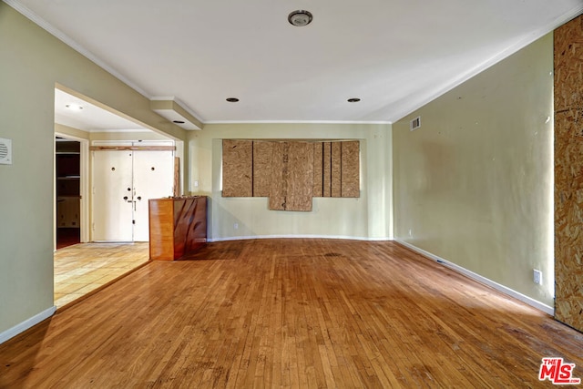 empty room featuring crown molding and hardwood / wood-style floors