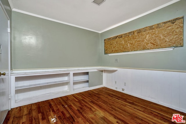 empty room featuring wood-type flooring and ornamental molding