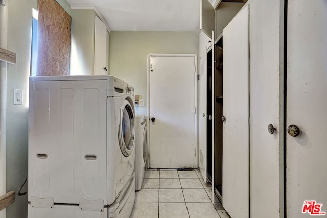 laundry area featuring light tile patterned floors, cabinets, and washing machine and clothes dryer