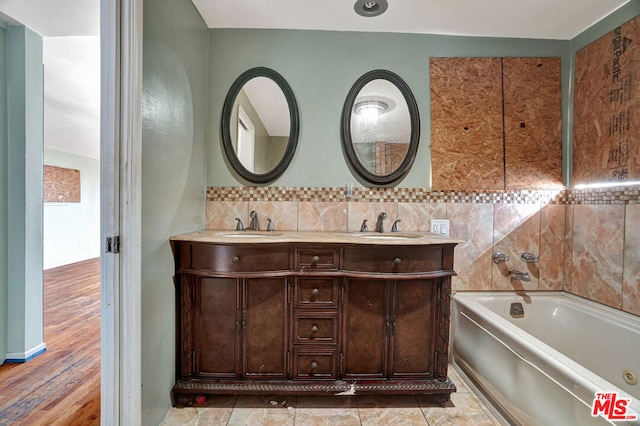 bathroom with tasteful backsplash, vanity, and a washtub