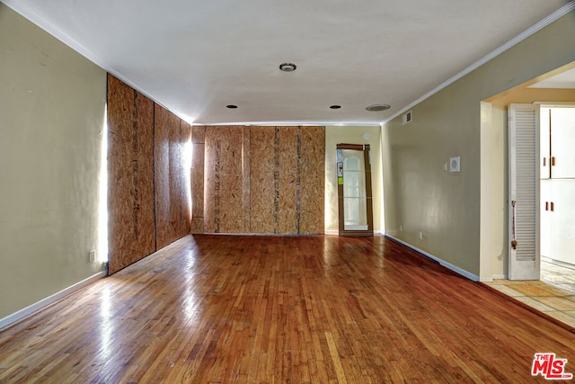 spare room featuring hardwood / wood-style flooring and crown molding