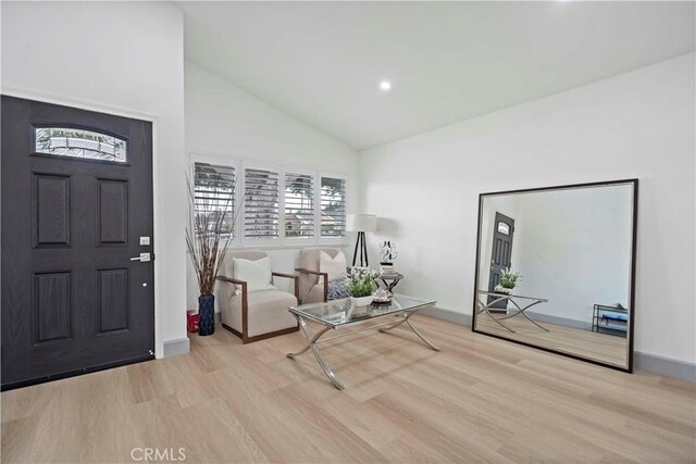 entryway with light hardwood / wood-style flooring and high vaulted ceiling