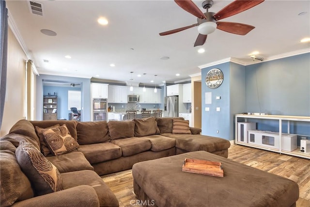 living room with crown molding, ceiling fan, and light hardwood / wood-style floors