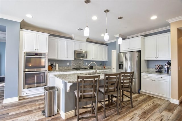 kitchen with stainless steel appliances, light wood-type flooring, visible vents, and white cabinetry