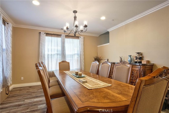 dining space with crown molding, dark wood-type flooring, and an inviting chandelier