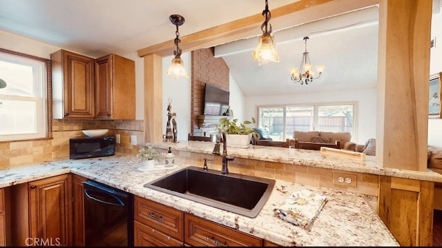 kitchen with sink, decorative light fixtures, black appliances, and light stone countertops