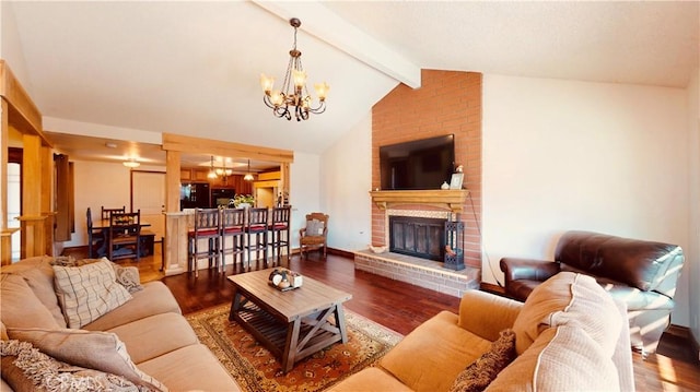 living room with an inviting chandelier, hardwood / wood-style floors, and a fireplace