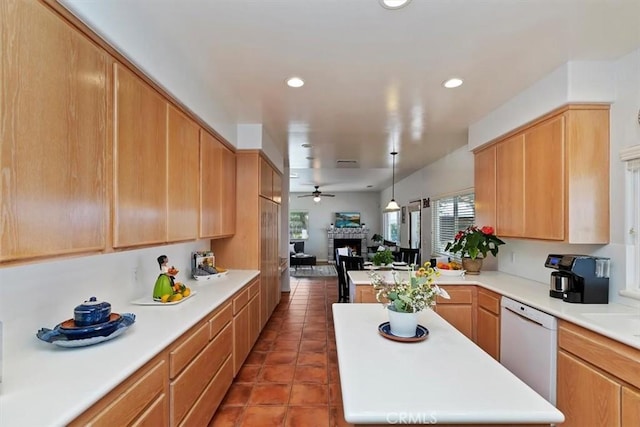 kitchen featuring a center island, white dishwasher, ceiling fan, a fireplace, and tile patterned flooring