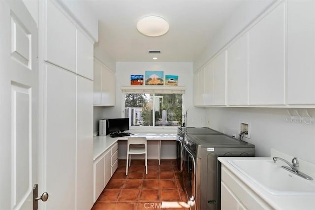 washroom featuring cabinets, separate washer and dryer, sink, and dark tile patterned flooring