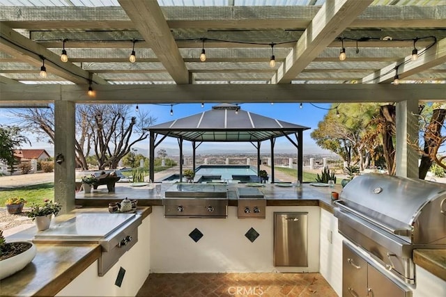 view of patio featuring a gazebo, an outdoor kitchen, and grilling area