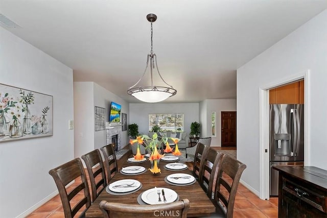 tiled dining area with a fireplace