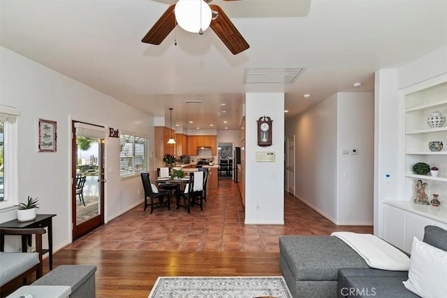 living room with light tile patterned floors, built in features, and ceiling fan