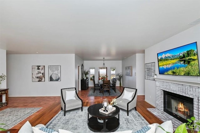 living room featuring a brick fireplace and wood-type flooring