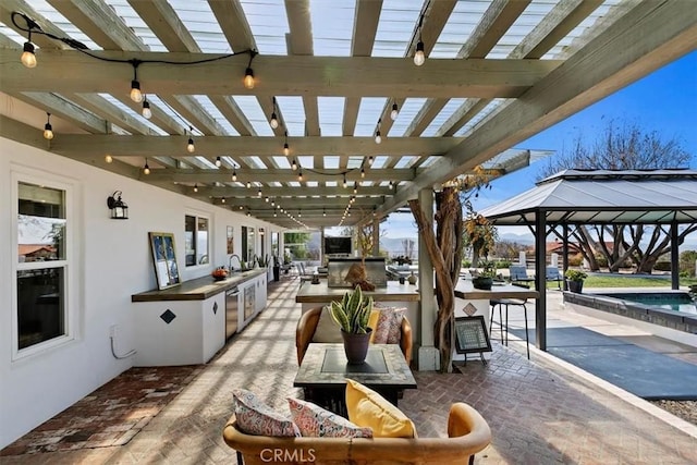 view of patio / terrace featuring a pergola, a gazebo, and exterior kitchen