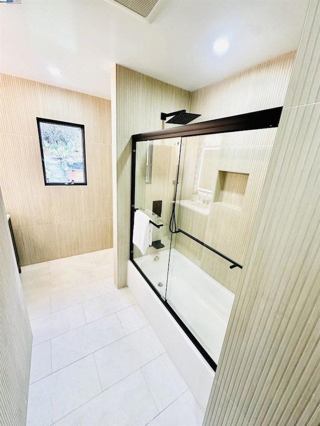 bathroom with combined bath / shower with glass door, tile walls, and tile patterned floors