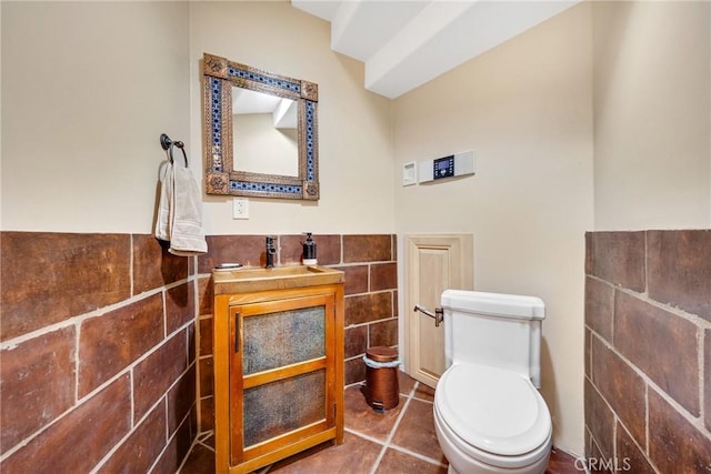 bathroom with vanity, tile walls, tile patterned floors, and toilet