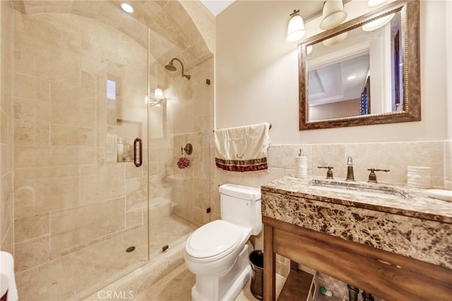 bathroom with vanity, toilet, a shower with door, and tile walls