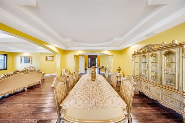 dining room featuring a raised ceiling and dark hardwood / wood-style floors