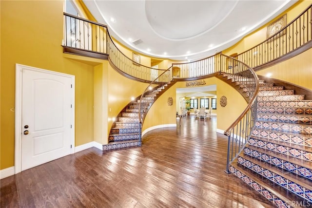 foyer featuring hardwood / wood-style flooring and a towering ceiling