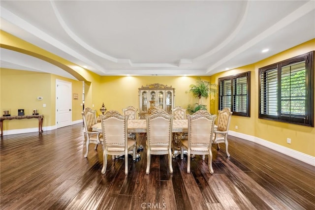 dining area featuring dark hardwood / wood-style floors and a raised ceiling