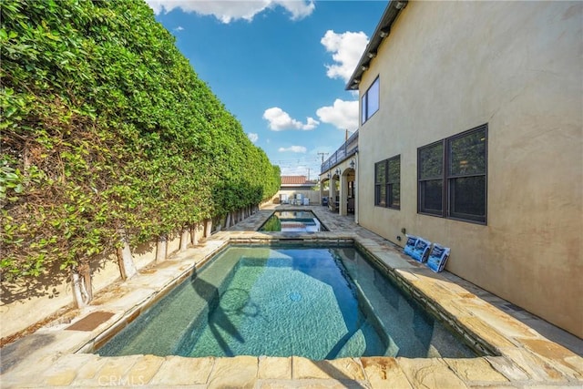 view of swimming pool featuring an in ground hot tub