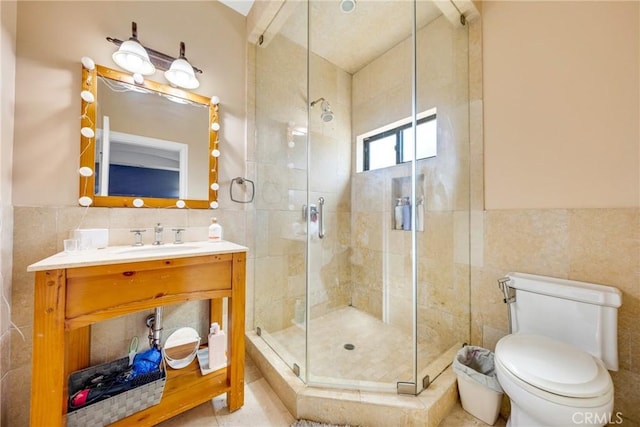 bathroom featuring tile walls, vanity, a shower with shower door, and toilet