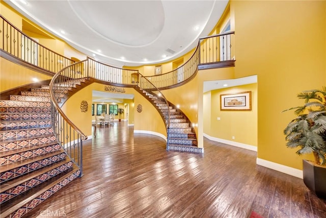 foyer entrance with hardwood / wood-style flooring and a high ceiling