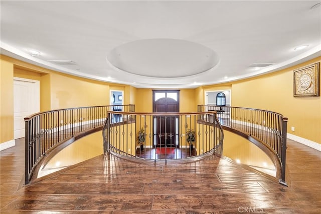 staircase featuring hardwood / wood-style flooring and a raised ceiling