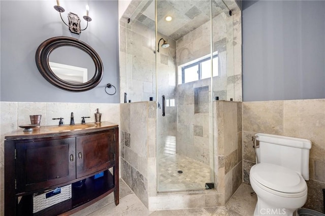 bathroom with vanity, toilet, an enclosed shower, and tile walls