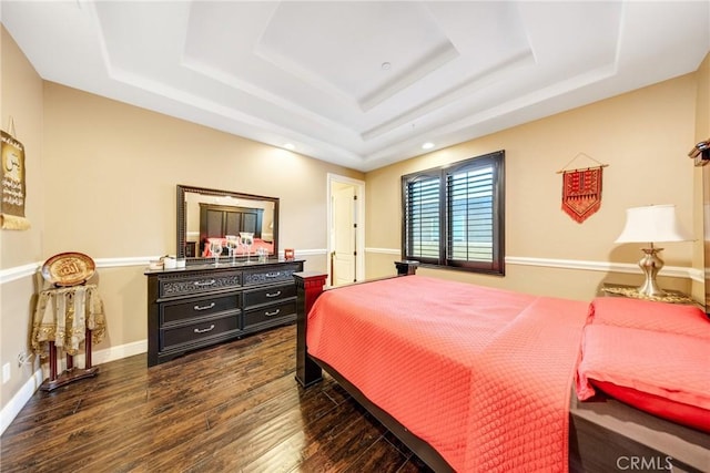 bedroom with dark wood-type flooring and a tray ceiling