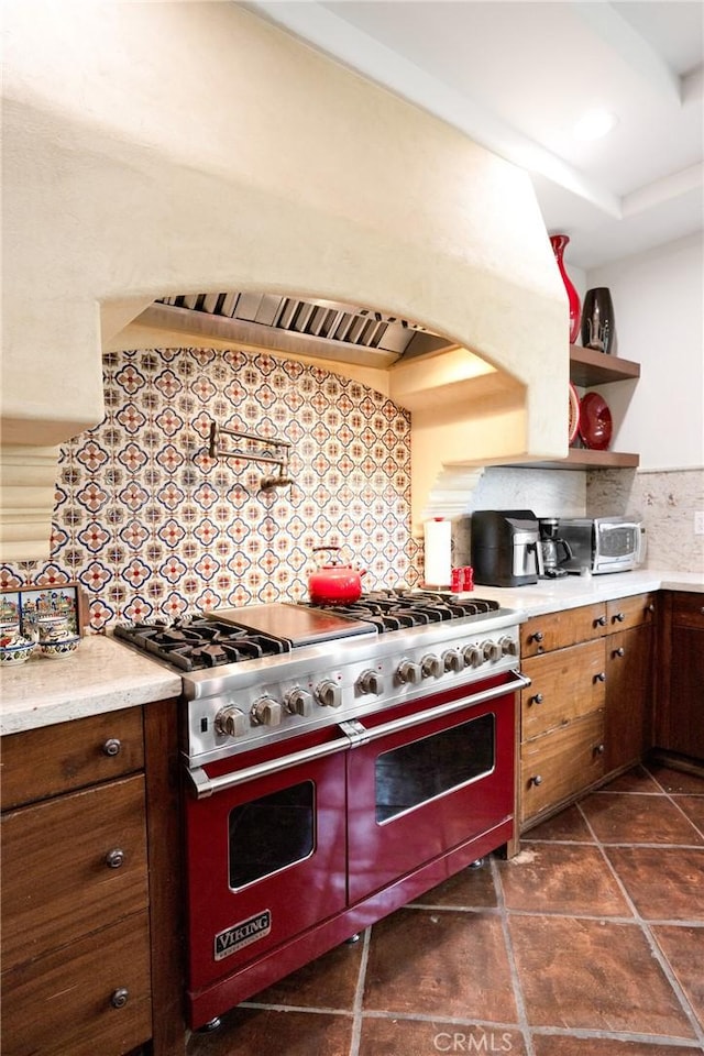 kitchen with premium range hood, decorative backsplash, and range with two ovens