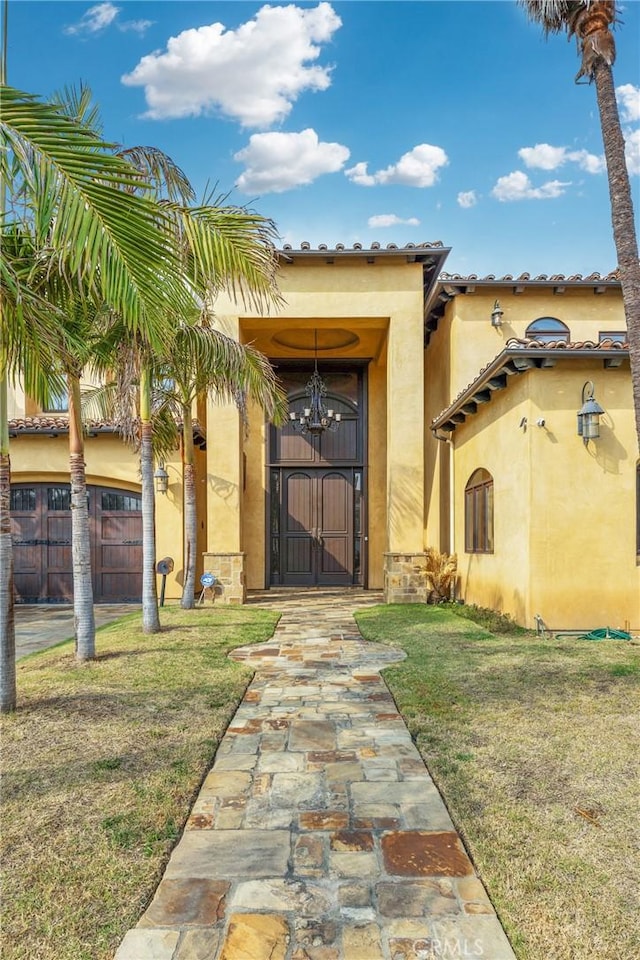 entrance to property featuring a lawn