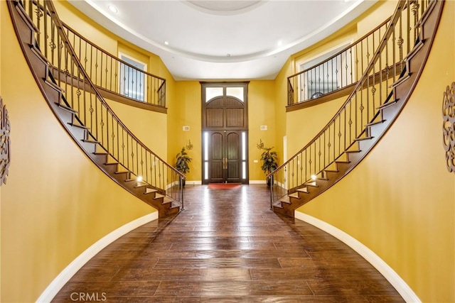 foyer with dark hardwood / wood-style floors and a high ceiling