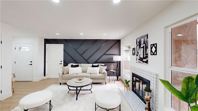 living room with a brick fireplace and light wood-type flooring