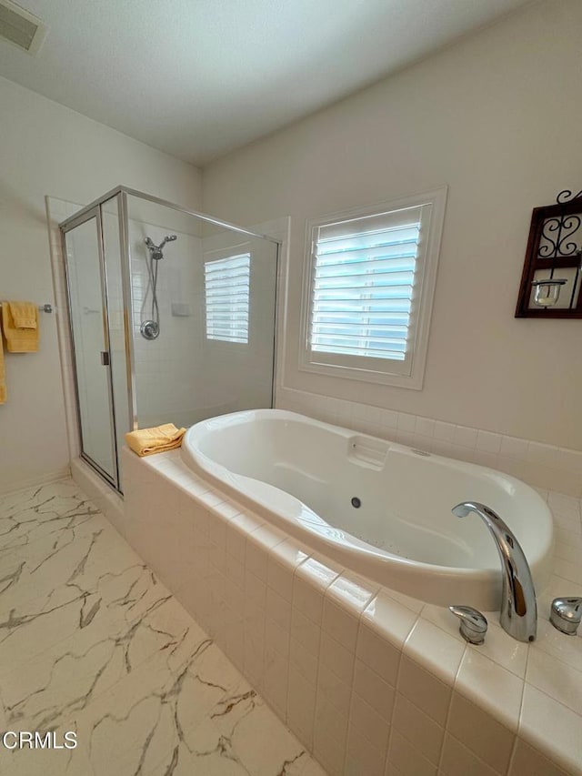 bathroom featuring separate shower and tub