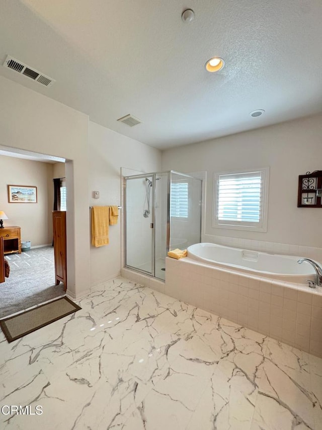 bathroom featuring separate shower and tub and a textured ceiling