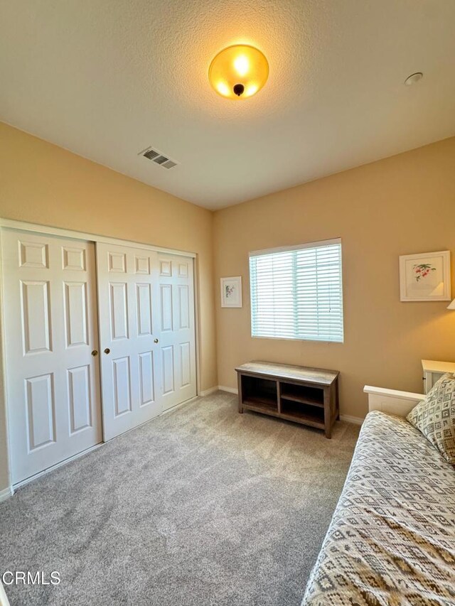 carpeted bedroom featuring a closet and a textured ceiling