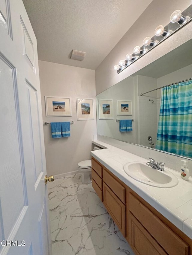 bathroom with vanity, toilet, a textured ceiling, and walk in shower