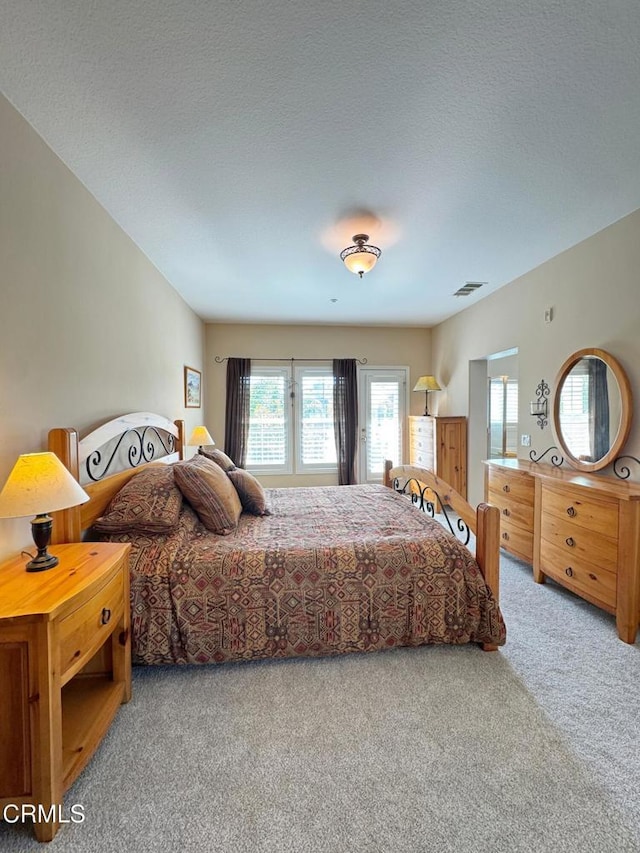 bedroom featuring carpet and a textured ceiling