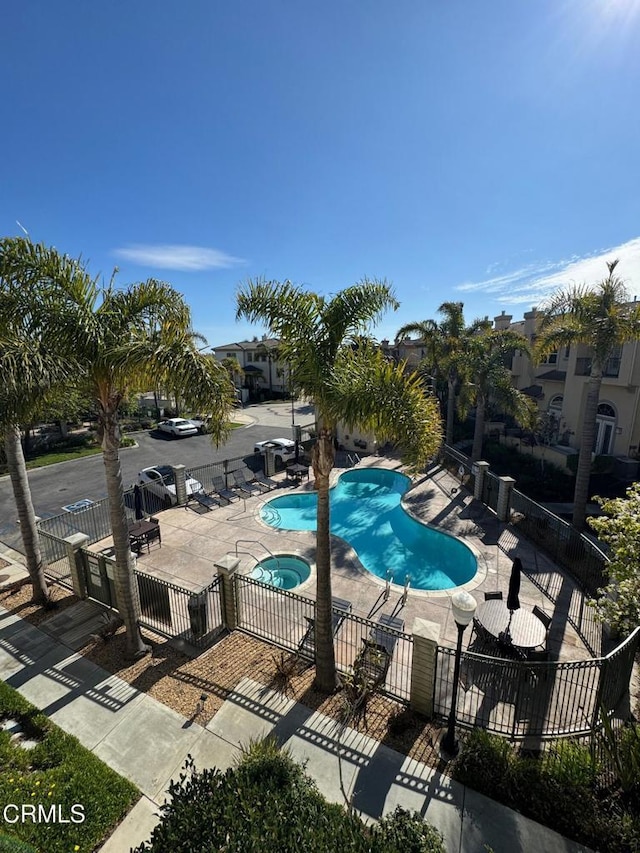 view of swimming pool with a hot tub and a patio area