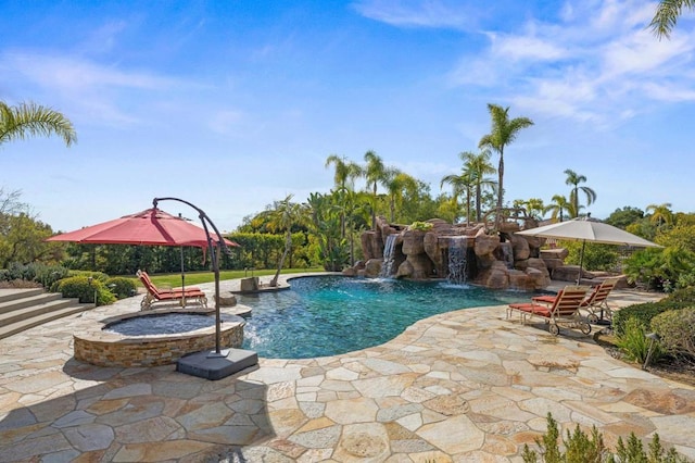 view of pool featuring an in ground hot tub, pool water feature, and a patio area