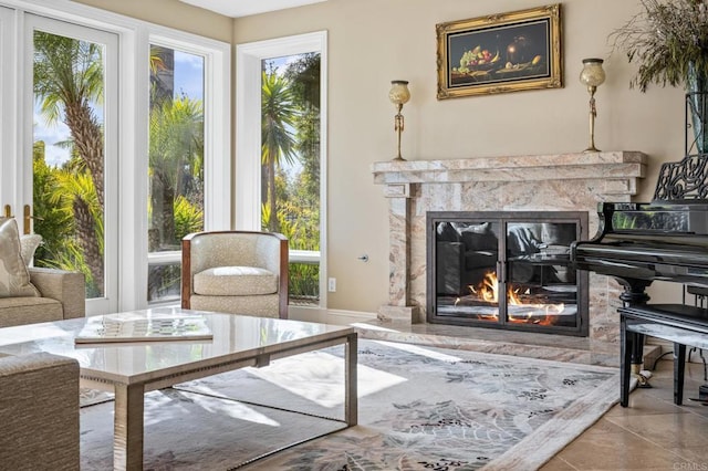 sitting room featuring a healthy amount of sunlight, a fireplace, and light tile patterned floors