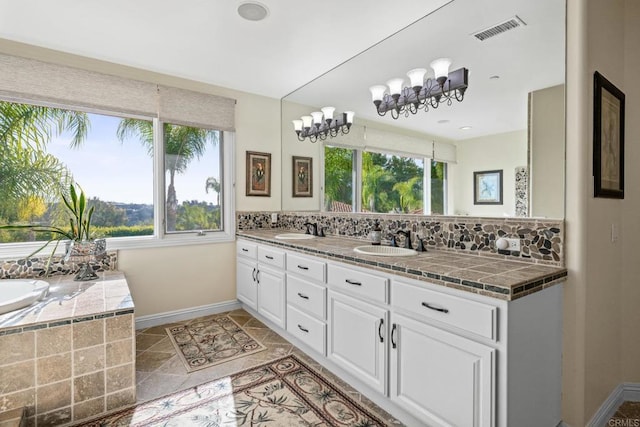 bathroom featuring vanity, tiled bath, and decorative backsplash