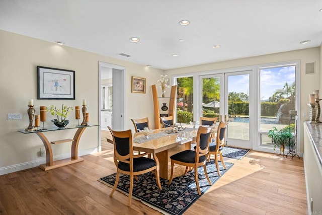 dining space with light hardwood / wood-style floors and french doors