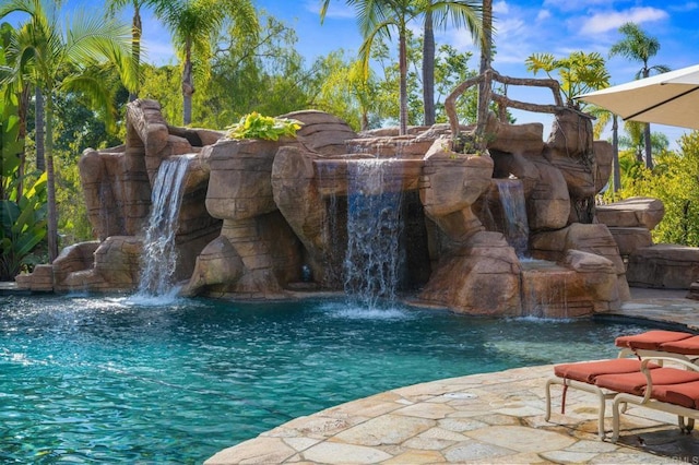 view of swimming pool with pool water feature