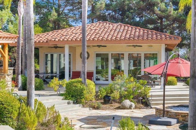 rear view of property featuring ceiling fan and a patio area