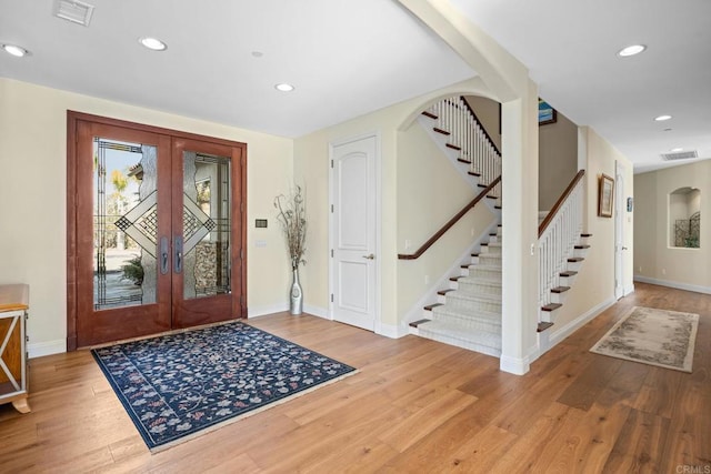 foyer entrance with french doors and light hardwood / wood-style flooring