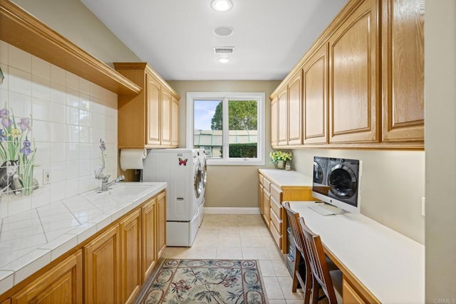 washroom with separate washer and dryer, sink, cabinets, and light tile patterned flooring