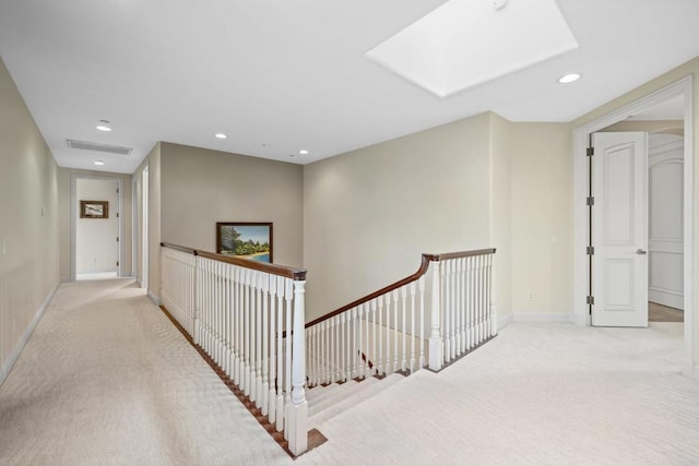 hall featuring a skylight and light carpet